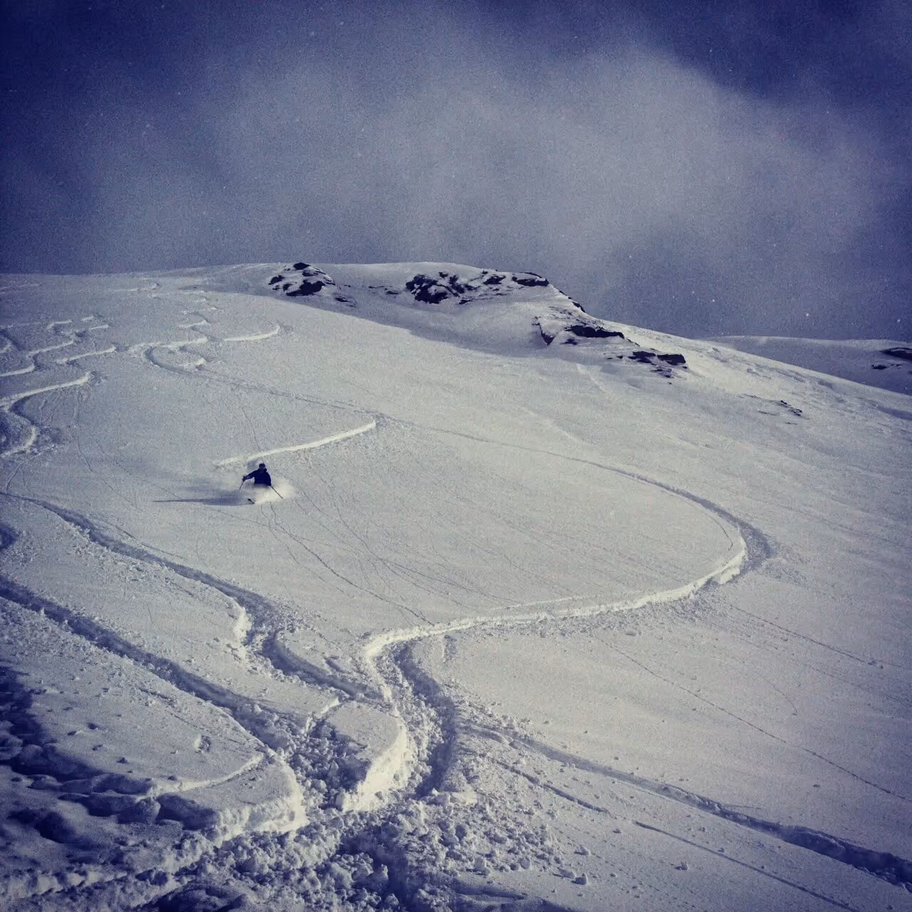 Fresh ski tracks in deep snow on the mountainside where the accident happened