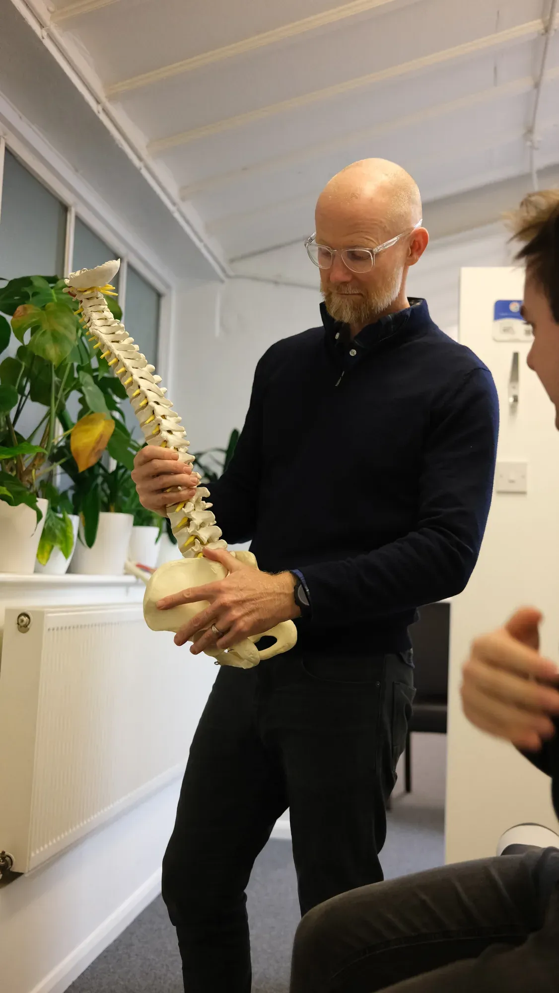 Chiropractor explaining spinal anatomy with a model spine at Putney Chiropractic Centre